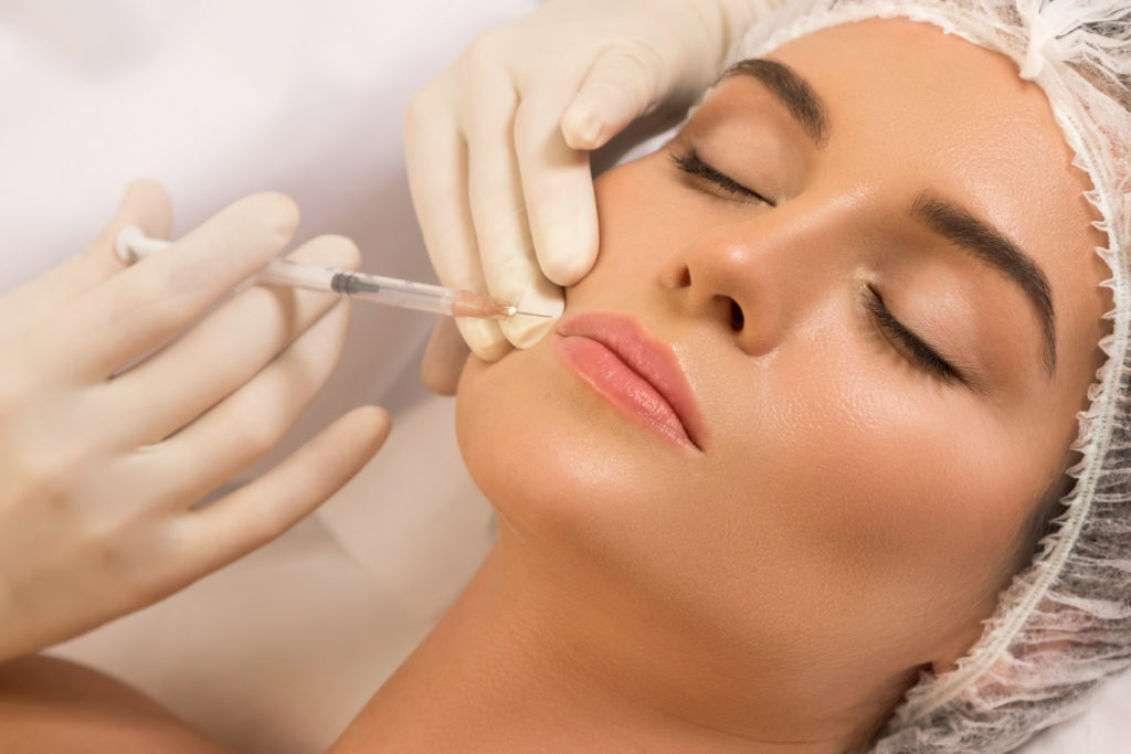 Woman during lips augmentation procedure | Perfectly Made Aesthetic Boutique in Prosper, TX