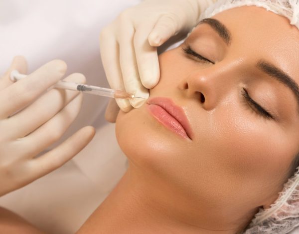 Woman during lips augmentation procedure | Perfectly Made Aesthetic Boutique in Prosper, TX